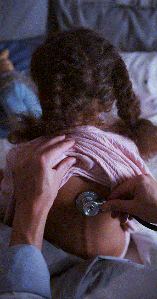 Doctor using stethoscope on child's back